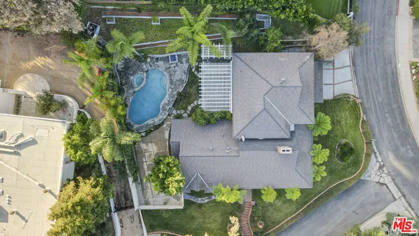 an aerial view of a house with garden space and street view