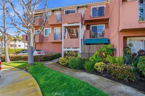 a front view of a multi story residential apartment building with yard and green space
