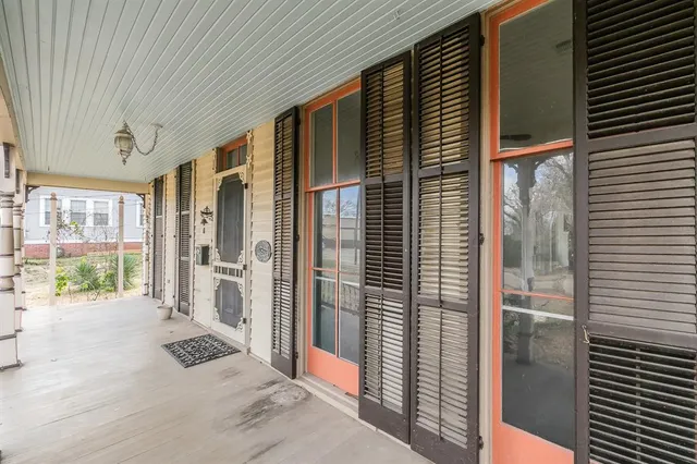 an empty room with wooden floor fireplace and windows