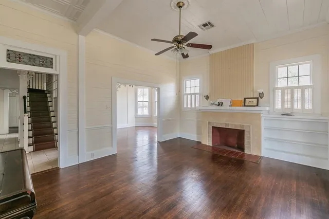 a view of a livingroom with wooden floor and a ceiling fan