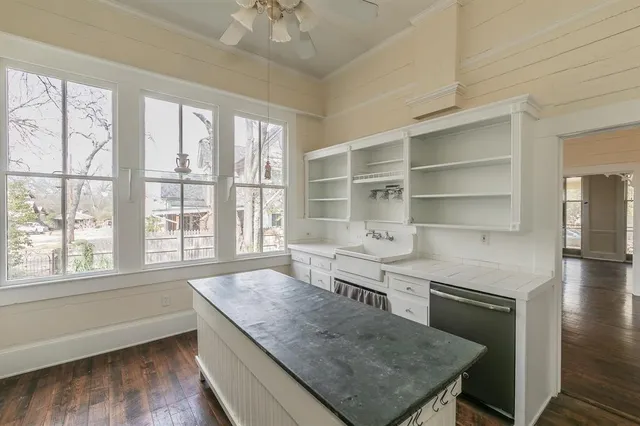 a kitchen with cabinets and wooden floor