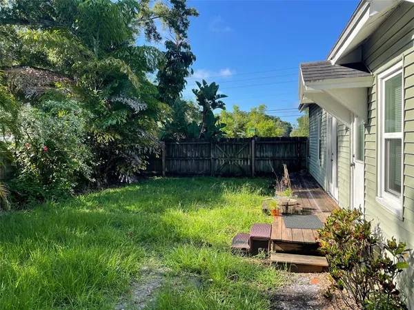 a view of a chair and table in backyard of the house