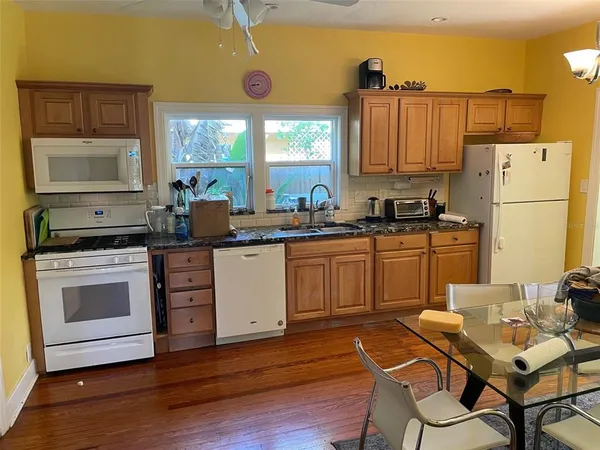 a kitchen with a sink cabinets and wooden floor