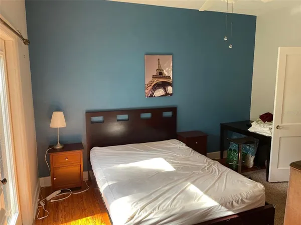 a bedroom with a bed and a lamp on dresser