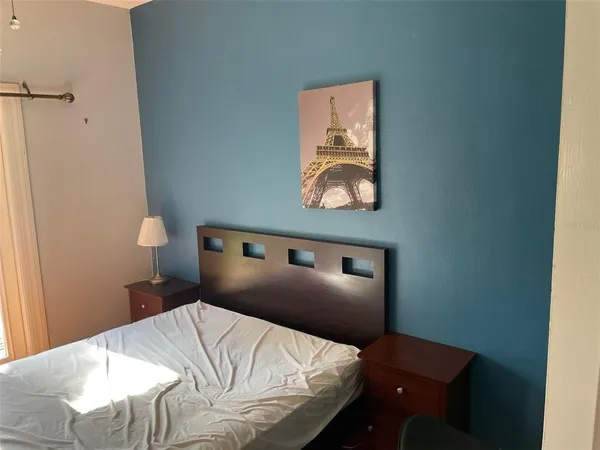 a bedroom with a bed and painting on the wall