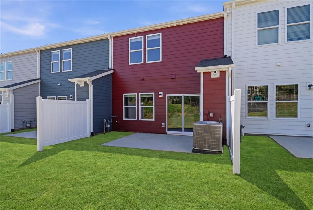 129 Kerwin Court Woodruff, SC 29388 - Photo 25 of 30 A vibrant townhome exterior features a private concrete patio, green yard, and white privacy fencing.