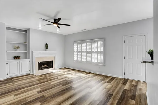 a view of an empty room with a fireplace and a window