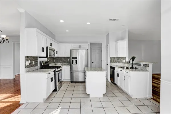 a kitchen with stainless steel appliances a white stove top oven cabinets a sink and a stove