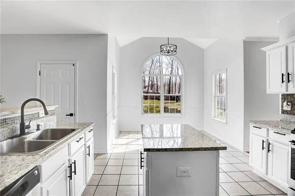 a kitchen with granite countertop a sink and cabinets