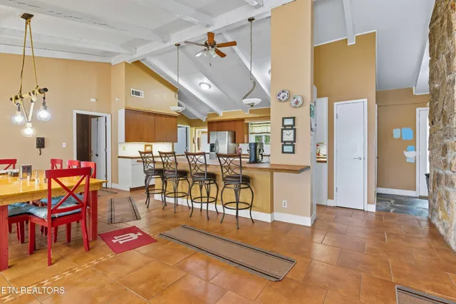 a living room filled with furniture and a open kitchen view