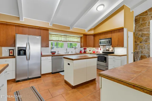 a kitchen with stainless steel appliances a refrigerator sink and microwave