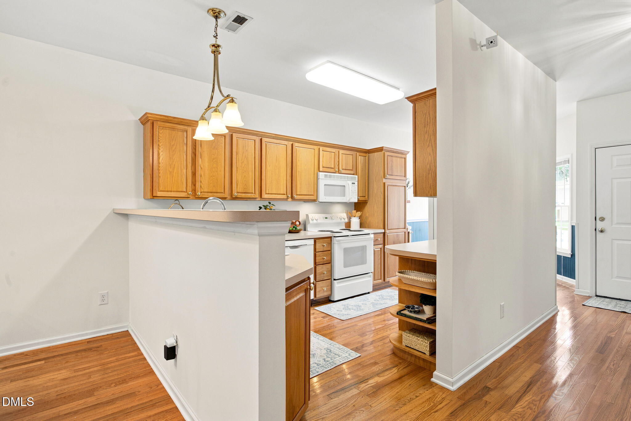 8211 Hempshire Place, Unit 104 Raleigh, NC 27613 - Photo 13 of 34 Kitchen featuring wood-finish flooring, wood cabinetry, white appliances, recessed lighting, and a breakfast bar