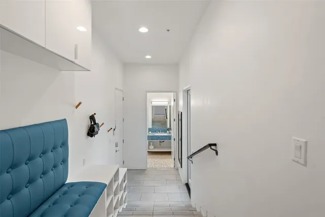 a view of a hallway with wooden floor and a bathroom