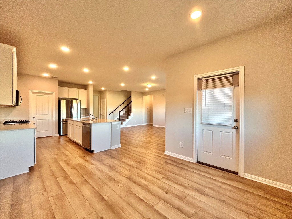13104 Zumpango Trace Manor, TX 78653 - Photo 37 of 37 Kitchen with white cabinetry, stainless steel appliances, open floor plan, light wood-type flooring, and recessed lighting