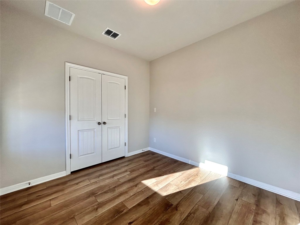 13104 Zumpango Trace Manor, TX 78653 - Photo 13 of 37 Unfurnished bedroom with wood finished floors and a closet