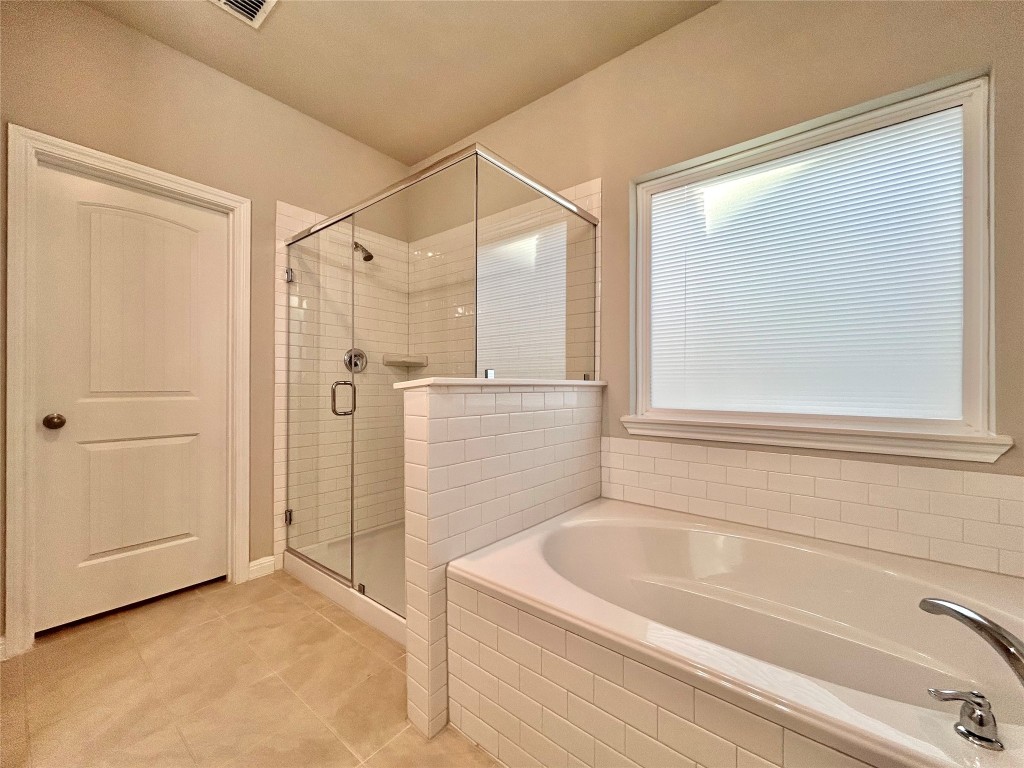 13104 Zumpango Trace Manor, TX 78653 - Photo 17 of 37 Full bathroom featuring a shower stall, a bath, and light tile patterned floors