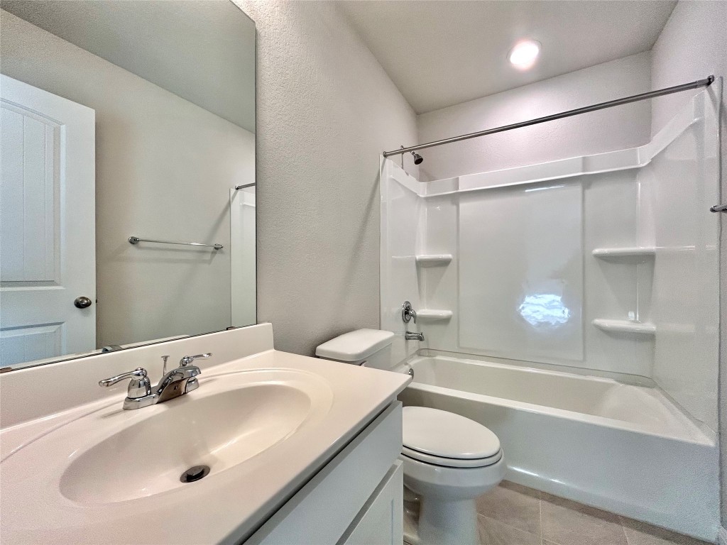 13104 Zumpango Trace Manor, TX 78653 - Photo 24 of 37 Full bath with bathtub / shower combination, vanity, a textured wall, and light tile patterned floors