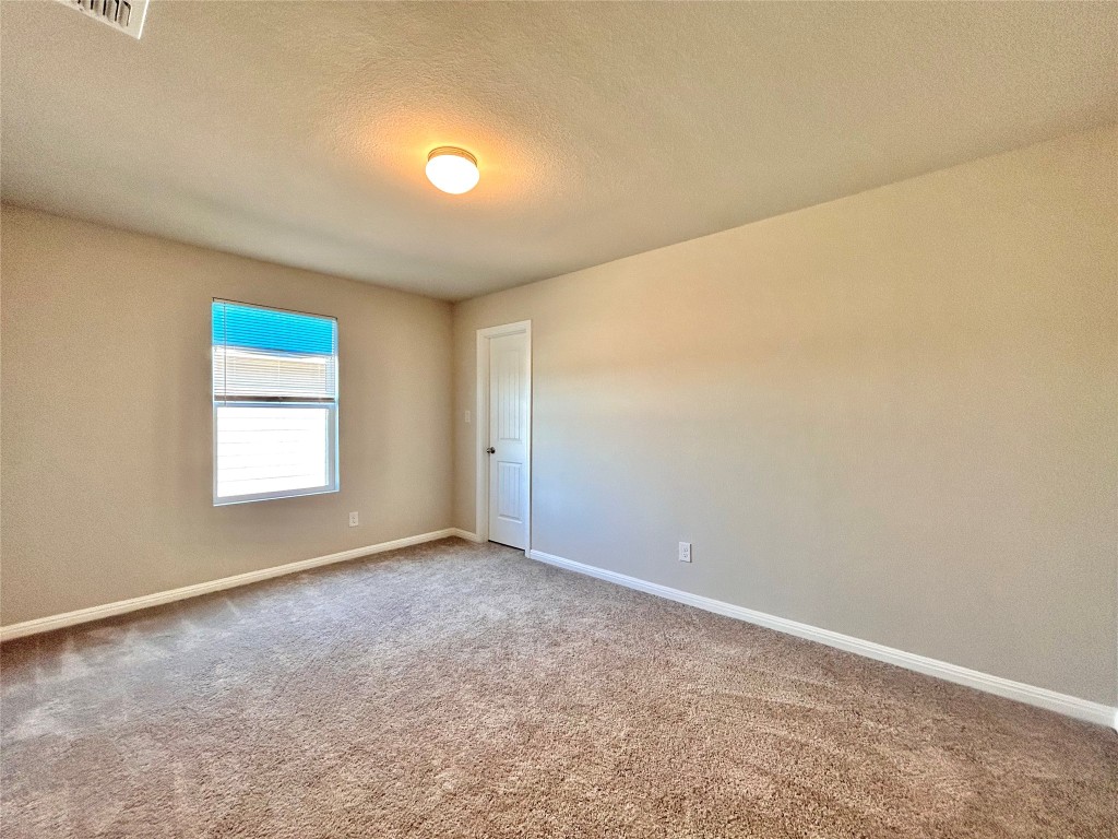 13104 Zumpango Trace Manor, TX 78653 - Photo 25 of 37 Empty room featuring a textured ceiling and carpet floors