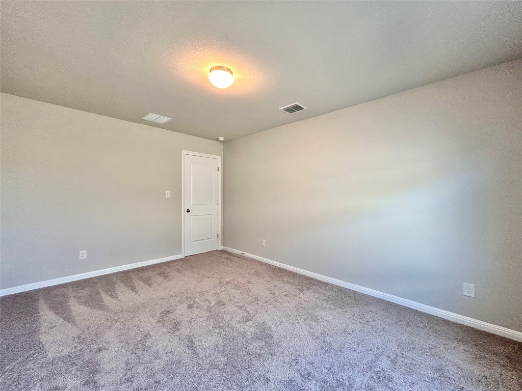 13104 Zumpango Trace Manor, TX 78653 - Photo 26 of 37 Carpeted spare room with baseboards and a textured ceiling