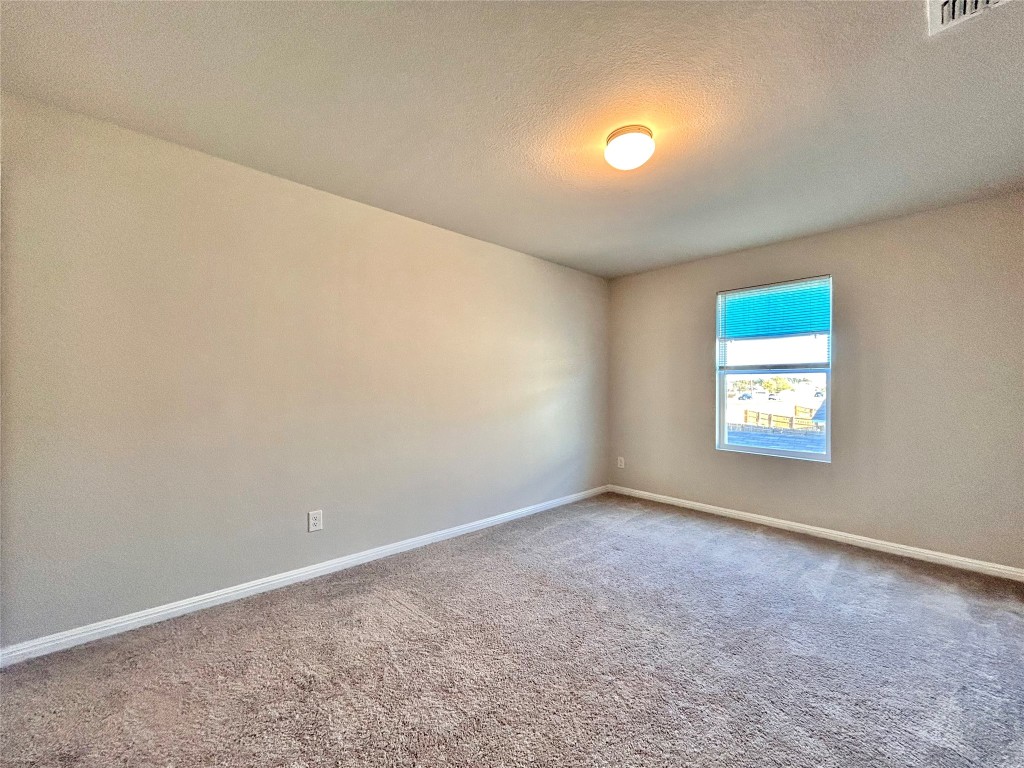 13104 Zumpango Trace Manor, TX 78653 - Photo 27 of 37 Carpeted spare room with a textured ceiling and baseboards