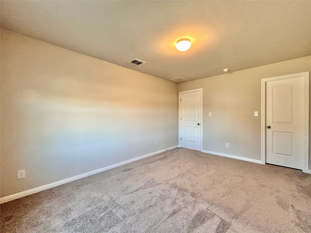 13104 Zumpango Trace Manor, TX 78653 - Photo 28 of 37 Unfurnished room featuring light colored carpet and a textured ceiling