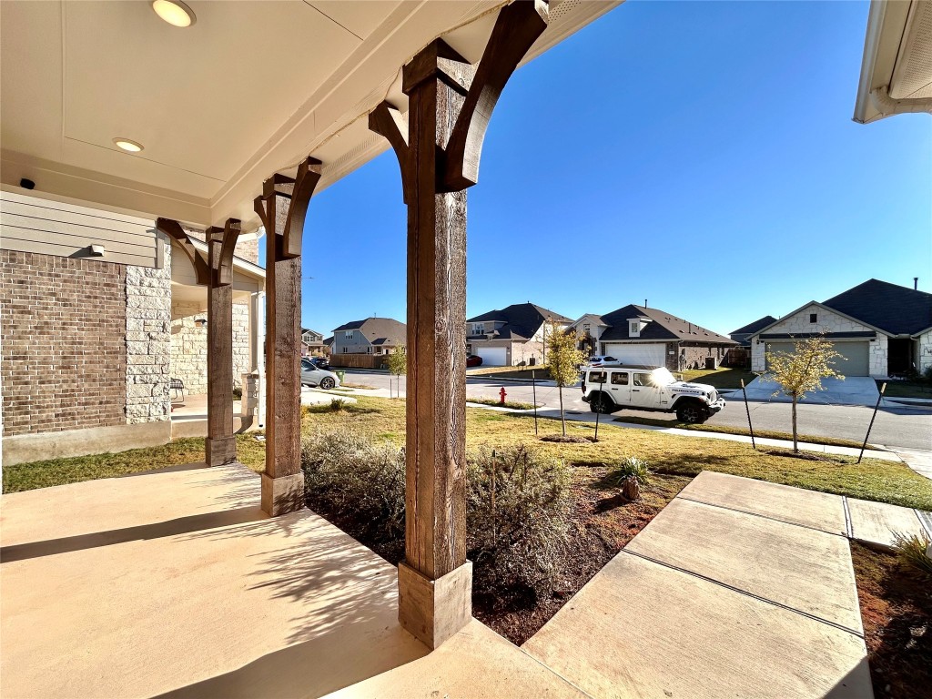 13104 Zumpango Trace Manor, TX 78653 - Photo 3 of 37 Porch featuring a residential view and a lawn