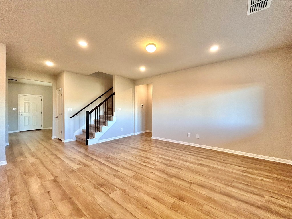 13104 Zumpango Trace Manor, TX 78653 - Photo 4 of 37 Unfurnished living room with stairway, light wood-type flooring, and recessed lighting