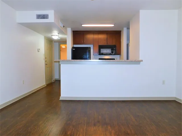 a view of empty room with wooden floor and a fireplace