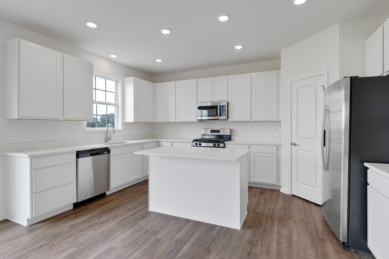 1464 Collins Street Elburn, IL 60119 - Photo 2 of 15 a kitchen with white cabinets and white appliances