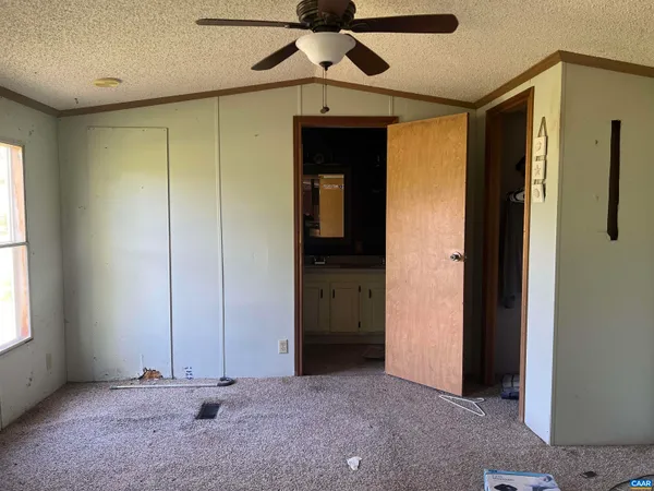 a view of a livingroom with wooden floor and a ceiling fan
