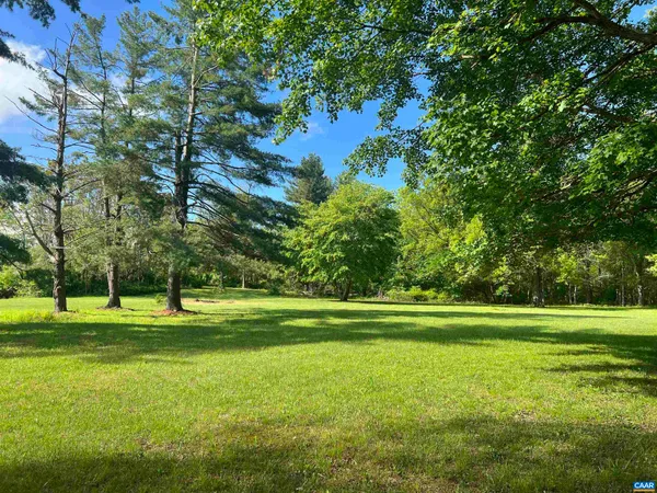 a backyard of a house with lots of green space and fountain