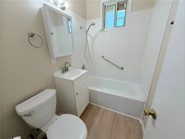 a white toilet sitting next to a bath tub