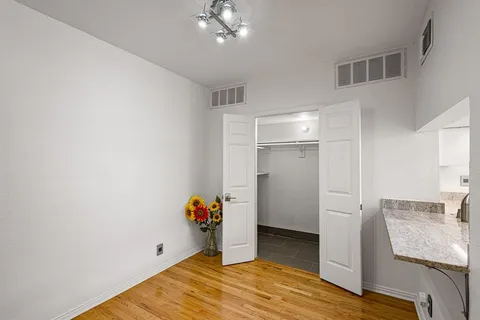 a view of empty room with wooden floor