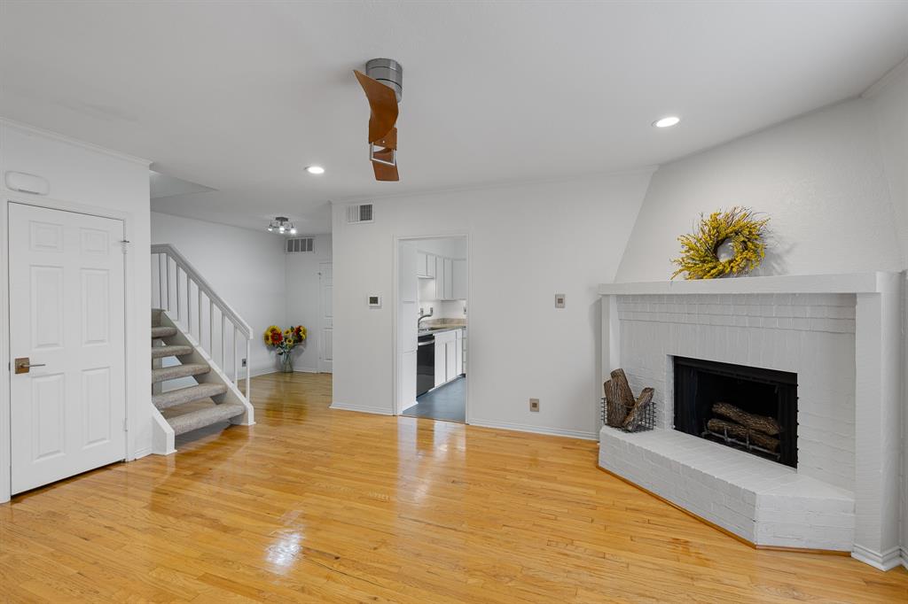 4130 Proton Drive, Unit 13A Addison, TX 75001 - Photo 19 of 40 Unfurnished living room featuring a brick fireplace, light wood-style floors, recessed lighting, and stairs
