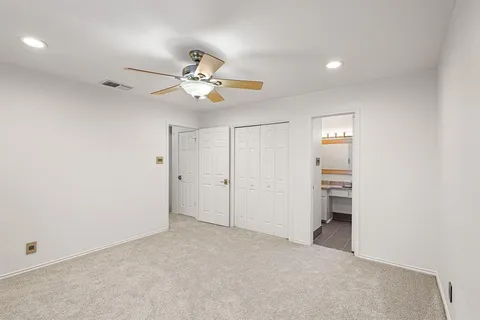 an empty room with a ceiling fan and a fan