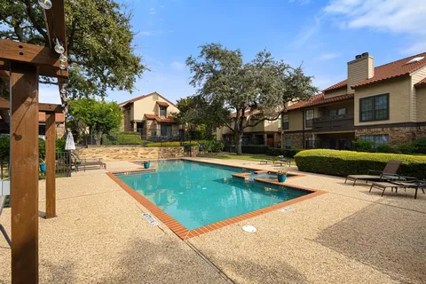 a view of swimming pool with outdoor seating and house in the background