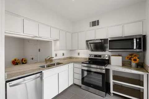 a kitchen with stainless steel appliances a stove a microwave and cabinets