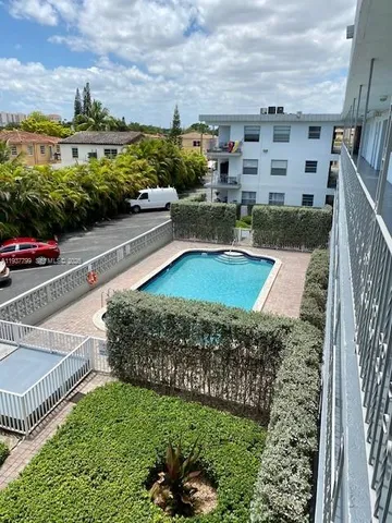 a view of a swimming pool with a garden and outdoor seating
