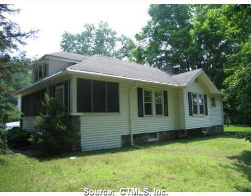 a view of a house with a yard potted plants and a table