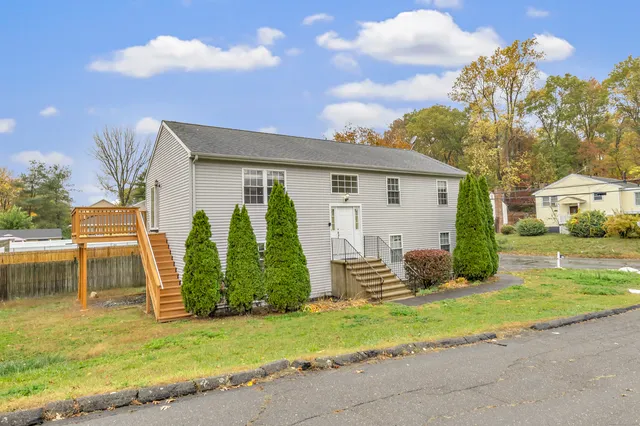 a view of a house with backyard and a tree
