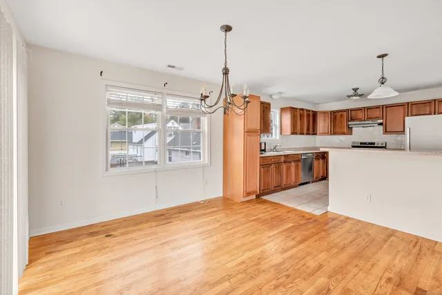 a kitchen with stainless steel appliances granite countertop a refrigerator a stove and a sink