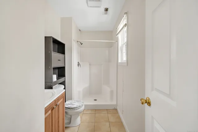 a bathroom with a toilet and a shower