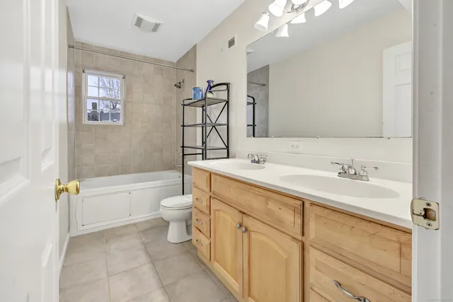 a bathroom with a toilet a sink a tub and mirror