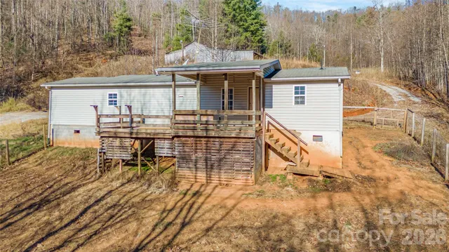 a view of house with wooden deck and furniture