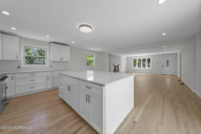 a kitchen with white cabinets and wooden floor