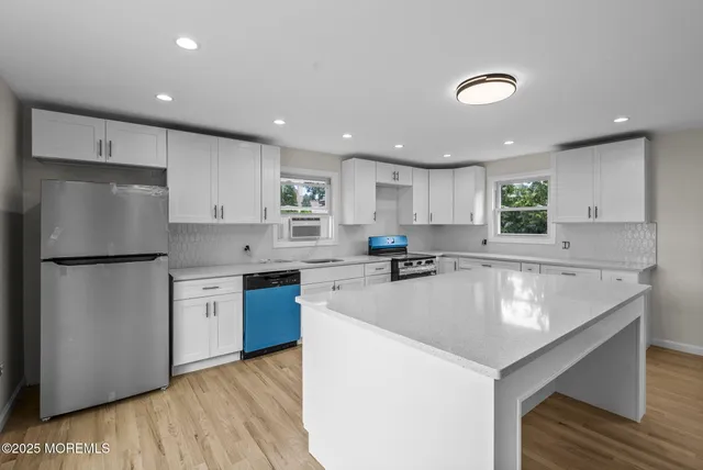 a kitchen with a refrigerator a sink and cabinets