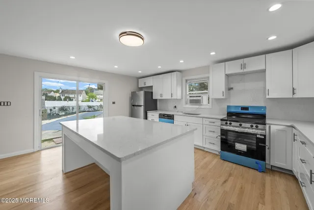 a kitchen with stainless steel appliances granite countertop a sink stove and refrigerator