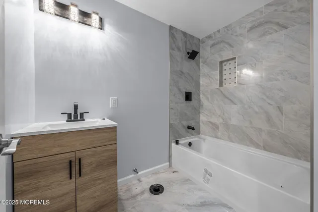 a bathroom with a bathtub sink vanity and toilet
