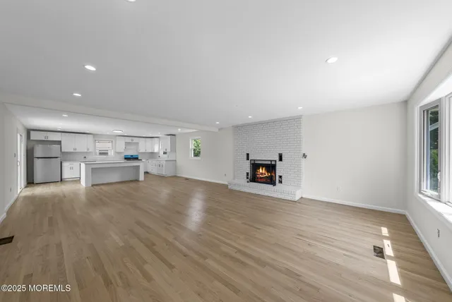 a view of empty room with wooden floor and window