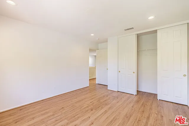 a view of a patio with a table chairs potted plants and palm trees